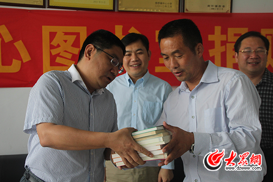 大眾網總編輯向該學校校長介紹捐贈有關書籍