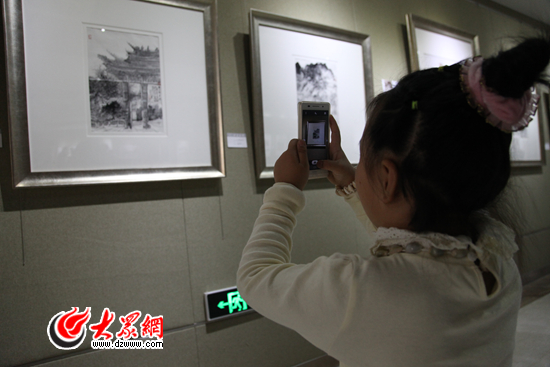 一位觀展的小女孩拍下展出的作品 記者 馬俊驥 攝.JPG