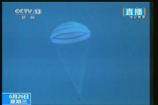 6月26日上午,神舟十號載人飛船返回艙返回地面。圖為神十返回艙主降落傘打開。(視頻截圖)